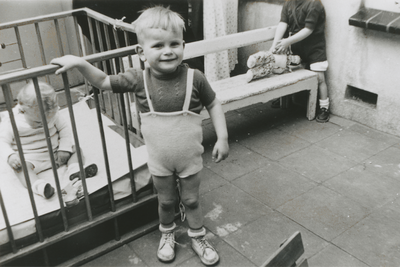876981 Portret van een jongetje op de binnenplaats van het opvanghuis 'Meisjesstad' (Oudegracht 35) aan de rand van ...